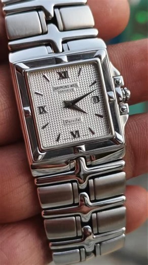 The Stone Age Antiques (Ajesh Jose) on Instagram: "Raymond Weil Genève Parsifal – Swiss Made Pre-owned Raymond Weil Parsifal featuring a classic square case with elegant guilloché dial, Roman numerals, and date window. Powered by a reliable Swiss quartz movement and fitted with its original integrated Raymond Weil steel bracelet. Signed crown present (cabochon stone missing – common with age, function unaffected). Overall in good working condition with normal signs of use. Details: • Swiss Made 