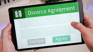 Reading and pressing the AGREE button at the end of a divorce agreement on a tablet screen. Digital agreement being accepted.