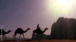 A camel train passes directly over the camera in the Saudi desert of Wadi Rum, Jordan.