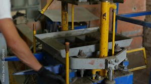 Work of press machine manufactured segmental pavers for road surface cover. Production process of interlocking concrete tiles