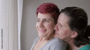 Gay senior lesbian couple hugging indoor at home - Diversity, LGBTQ lesbian family and love concept