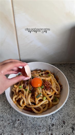 miso carbonara udon ingredients: 1 udon packets (fresh or frozen) 50g of guanciale freshly cracked black pepper 1/4 wedge parmigiano reggiano 2 eggs - just the yolks 1 tbs miso paste green onions, to garnish method: 1. cut your guanciale about 2cm in length and half a cm in width. 2. add to a cold pan and let the guanciale crispen up on low/medium heat. save the fat, we will need it. 3. grate your cheese, on the extra fine setting. 4. separate your eggs and add the yolks to the cheese, add in a 