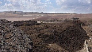 Aerial shot of an Industrial compost production site. Tractors loading compost into machines and trucks Stock Video