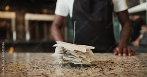 Close-up shot: a man puts a check with the rest of the checks on a special metal rod for checks. Facility tracking