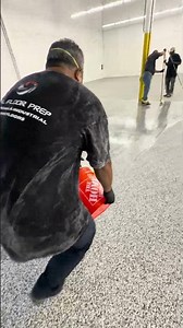 Applying a clear coat of epoxy on a flake floor in an industrial warehouse West Babylon, New York