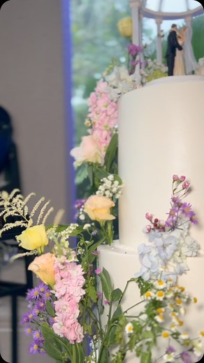 💡Unique cake idea: when your cake topper replicates your venue ✨🍰 Six tiers of pure bliss! Each floral detail is passionately handpicked to mirror our couple's dream, making this all-white wedding cake a true labor of love. 🌸💖 | Cake Studio