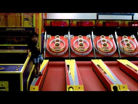 Baby hits jackpot on skeeball at Chuck e Cheese.