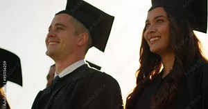 Graduation cap, students and group celebration for success, learning achievement and university applause. Happy friends, students or graduate class clapping and congratulations outdoor in lens flare