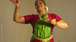 A lovely young woman using traditional mudra or hand gestures to tell a story during classical Indian dance.