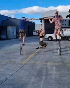 Trio of Acrobats Performs Traditional Unicycle Trick