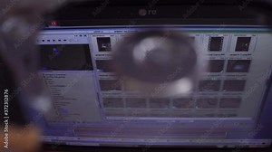 The hard disk is lying on the table, blinking and spinning the disk. Work of a hacked hard drive inside. Computer security. Internal structure of the hard disk. Lines of code and data flash in the bac