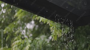 Rain water dropping from roof in day time. Raining in motion. Slow motion.