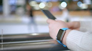Smart watch on woman's hand . Woman's hand touching a smartwatch. Female's hand uses of wearable smart watch with smartphone.