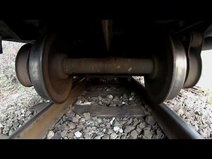 Undercarriage view of a narrow gauge train.