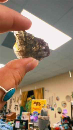 Did ya know… Axinite is highly pleochroic, displaying distinct, different colors—typically honey-brown, violet, and pale yellow or smoky grey—when viewed from various angles or under polarized light. This strong, three-color (trichroic) shifting effect is a hallmark characteristic of the mineral group, particularly visible in faceted gems and raw, tabular crystals. Axinite is associated with grounding and connecting to Earth energies, as well as opening the Third Eye and Root chakras. It is beli