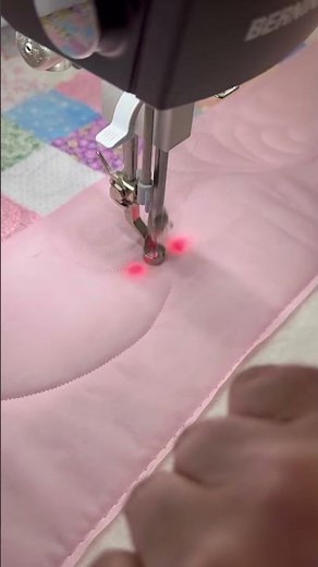 Quilting free-motion feathers on quilting machine.