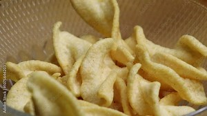 Crispy potato chips falling to the glass bowl close up shot. Delicious potato spring chips close up video. Concept of unhealthy fast food or junk food snacks. Stock Video