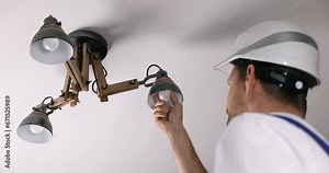 handyman services. electrician replace led light bulb in ceiling lamp at home