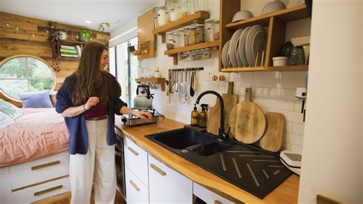 🏡 Tiny House Tour Highlights: The warm, welcoming kitchen with its generously sized sink, overhead dish rack, and smart storage solutions. A workstation with a stunning macrocarpa slab, merging functionality with aesthetics. Innovative storage solutions, including her beloved IKEA drawers - perfect for maximizing space. A cozy bedroom with a unique round window, giant view window, and ample storage under and behind the bed. The spacious outdoor area – a deliberate addition to host friends and g