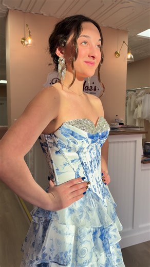 Ruby Mae’s on Instagram: "Soft, romantic, and made for a moment ✨ This white + blue floral gown is giving main-character energy in the sweetest way — layered ruffles, a dreamy silhouette, and an embellished top that catches the light just right. Perfect for the girl who wants a little soft elegance. Currently in store in a size 4, and available to order in any size. Prom season is calling 🤍 Come try her on at Ruby Mae’s. ✨ www.shoprubymaes.com 🕰️ Open Wednesday–Saturday 12–6 Sunday–Tuesday by 
