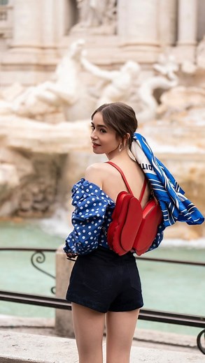 Abigail Goodman on Instagram: "What scarf is Emily, as played by Lilly Collins, wearing in “@emilyinparis”? This scarf ID was highly requested this week— so let’s do it! In S4E9, entitled “Roman Holiday”, Emily travels to Rome and takes inspiration from two important fashion icons, Audrey Hepburn and Lizzie McGuire😂. The star of the main outfit in this episode is definitely the scarf that is tied in her hair. We can see it’s a bit art deco, with its bold text and stylized women and we can also 