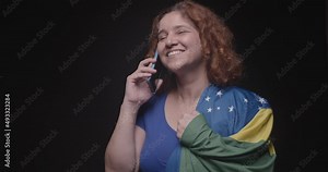 Woman supporter of Brazil, fan of Brazil, World Cup, Olympics, moving, browsing and talking on the cell phone. technology