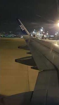 夜の伊丹空港に到着しスポットインする ANA エアバスA321の機窓から空港の夜景を撮影