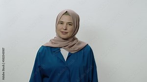 The headscarved woman is very angry at what happened.She shouts explaining that he is angry. Portrait of angry woman. Indoor studio shot isolated on white background.