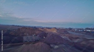 Flying low and slow over construction site sand piles, drone perspective view with motion blur, dirty and wet industrial site, aerial footage. Shot with Gopro Hero 5 black 2.7K.