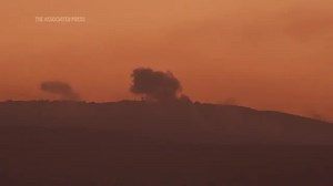 Israeli military helicopter seen over southern Lebanon as smoke plumes along the border