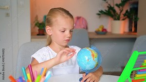 Home education for children girl shows country on globe. Schoolgirl is studying the globe. Globe map model for travelling.