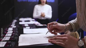 Process of checking in on a conference congress forum event, registration desk table, visitors and attendees receiving a name badge and entrance wristband bracelet and register electronic ticket