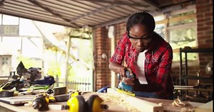 An African American carpenters are using spoke shave to decorate the woodwork.