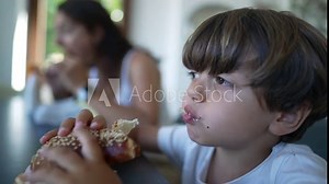 Little boy eating sandwich. Child taking a bite of bread. Kid eats delicious carb food