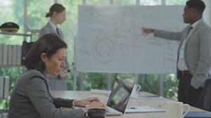 Senior woman teacher working with college students in library and being consulting new project during a break.