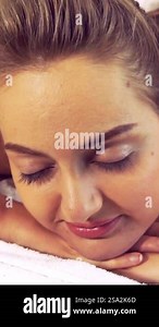 Relaxed young woman lying on spa bed for body scrubbing massage using traditional herbs and spices by massage therapist in a luxury spa resort. Wellness, stress relief and rejuvenation concept Stock Video Footage - Alamy