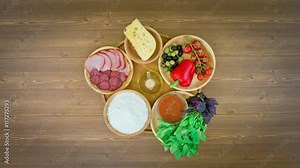 pizza with ingredients on wooden plate on the table - stop motion animation, 4K