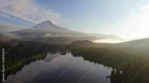 Trillium Lake drone aerial cinematic Mount Hood Oregon reflection calm water fishing camping canoeing snow ski trails early morning golden yellow sunrise beautiful peaceful forward pan movement