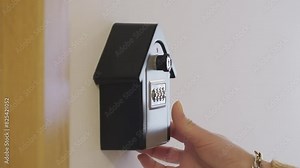 Hand entering code and opening lockbox to take out key from the inside