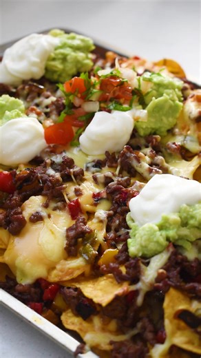 10K views · 187 reactions | Cheesy Beef Nachos!燎 Here's the detailed recipe: https://thebigtastybite.com/cheesy-beef-nachos/ What’s your favourite nacho combo? (and yes, I accidentally said "toating" instead of "toasting" ‍) | The Big Tasty Bite | Facebook