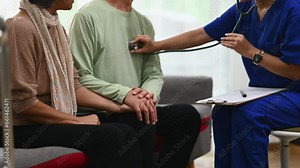 Female doctor using stethoscope examining senior male during home care visit. Elderly healthcare concept