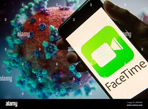 In this photo illustration the  Apple's video and audio calling service company FaceTime logo seen displayed on a smartphone with a computer model of the COVID-19 coronavirus on the background Stock Photo - Alamy