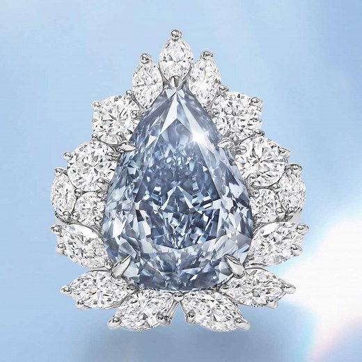 The majestic Winston Blue is poised at the center of a diamond and platinum ring; elegantly framed by a halo of complementing diamonds to accentuate the beauty of its pear-shaped form. | Harry Winston