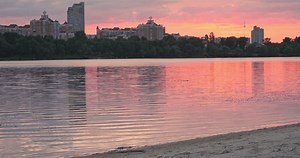 clip-1107563959-lonely-woman-walks-along-river-beach-pink