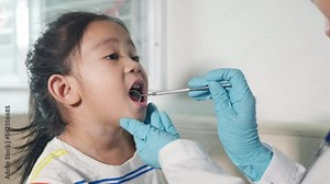 Dental kid health examination. Asian dentist making examination procedure for cute little girl open mouth, Doctor examines oral cavity of little child uses mouth mirror to checking teeth cavity