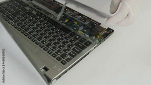 The master disassembles the laptop case for repair. Laptop repair. Computer repair service