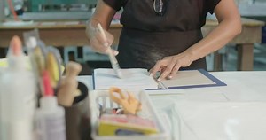 Hardcover Book Manufacturing Glue Binding Cover Medium. view moves from left to right on a worker applying glue to stick to the hardcover book manufacturing