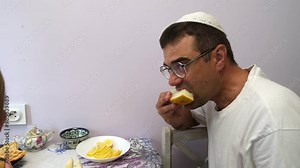 jewish family celebrating hanukkah, israel, boy in kippah, jewish holidays, yom kippur feast, table with food, honey, donuts, family holiday, religious family, family praying,