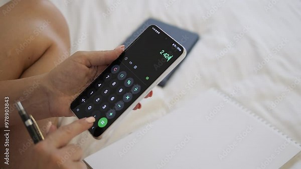 Woman managing accounting tasks on phone, reviewing financial data, and making calculations. Phone screen displays spreadsheets and numbers. Phone plays key role in efficient and mobile bookkeeping.