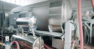 Alcohol production concept. Large steel barrels for wine fermentation. Wine production plant. Steel wine distilling tanks.